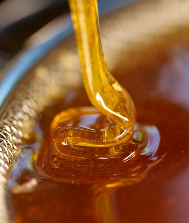 Goldener Honig blättert bei der Honigernte aus der Honigschleuder